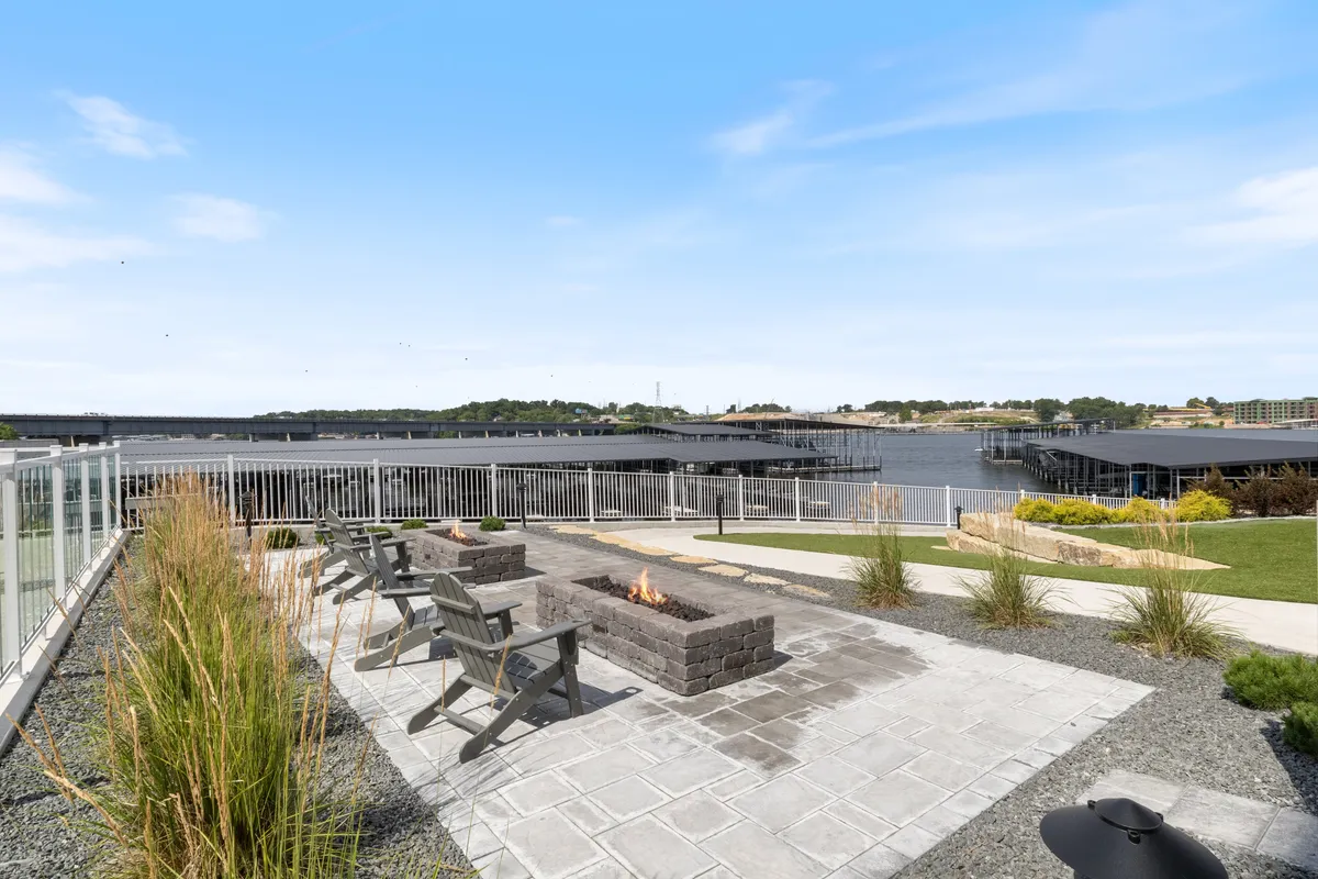 A cozy fire pit area with ample seating, set near the water and surrounded by lush greenery. The space invites groups to gather, share stories, and unwind after a day of exploration or water sports.